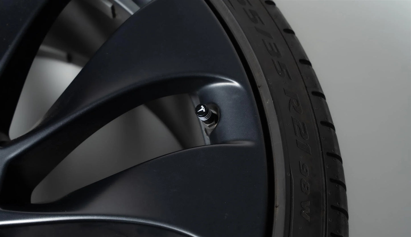 Photo zoomée d'un bouchon de valve arborant le logo T de Tesla