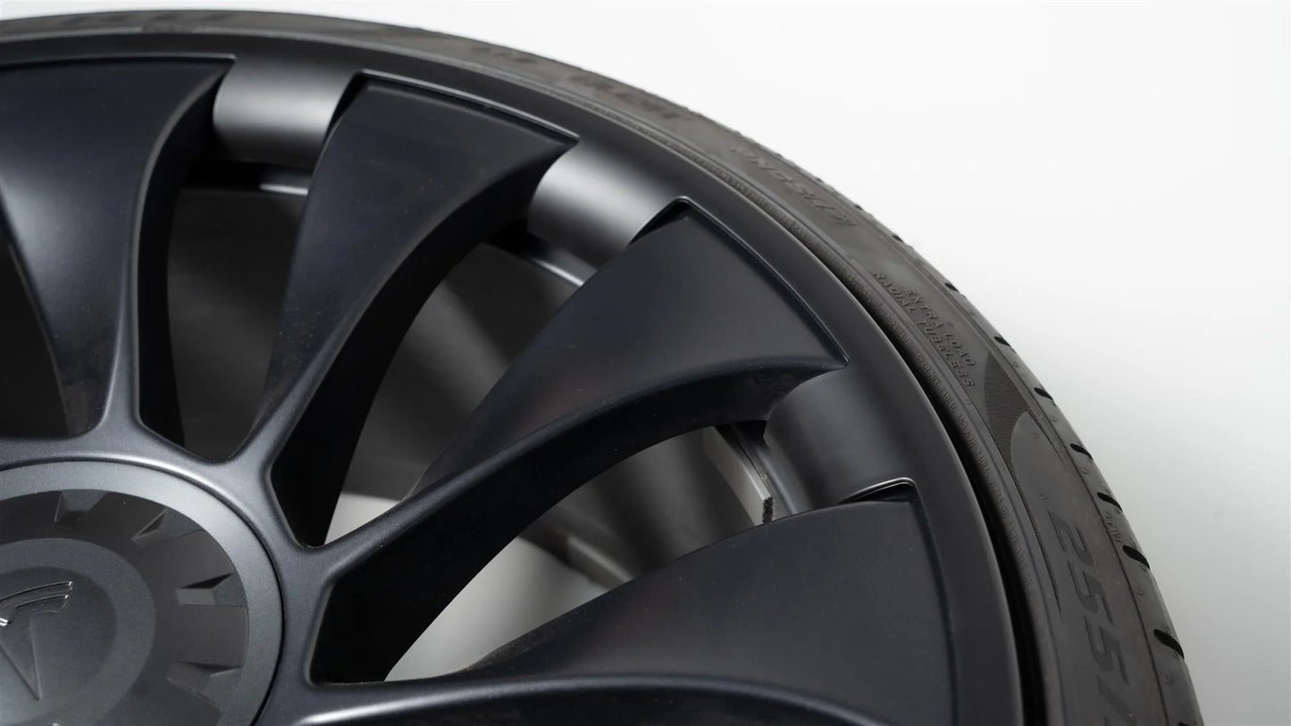 Photo zoomée de l'une des protections pour les jantes "Uberturbine" de la Tesla Model Y installée sur une roue.