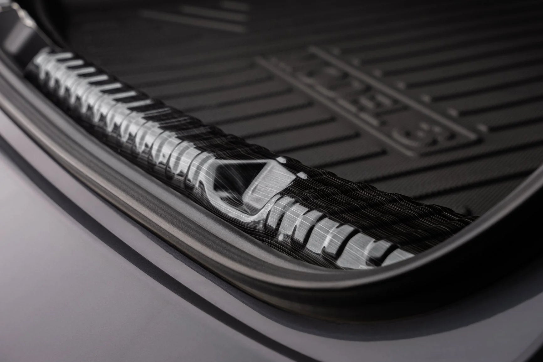 Caches de protection noirs pour le seuil de chargement du coffre d'une Tesla Model 3 Highland, installés sur un véhicule.